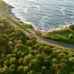 Route départementale 912 longeant les falaises de flysch et l’Atlantique, vue aérienne.