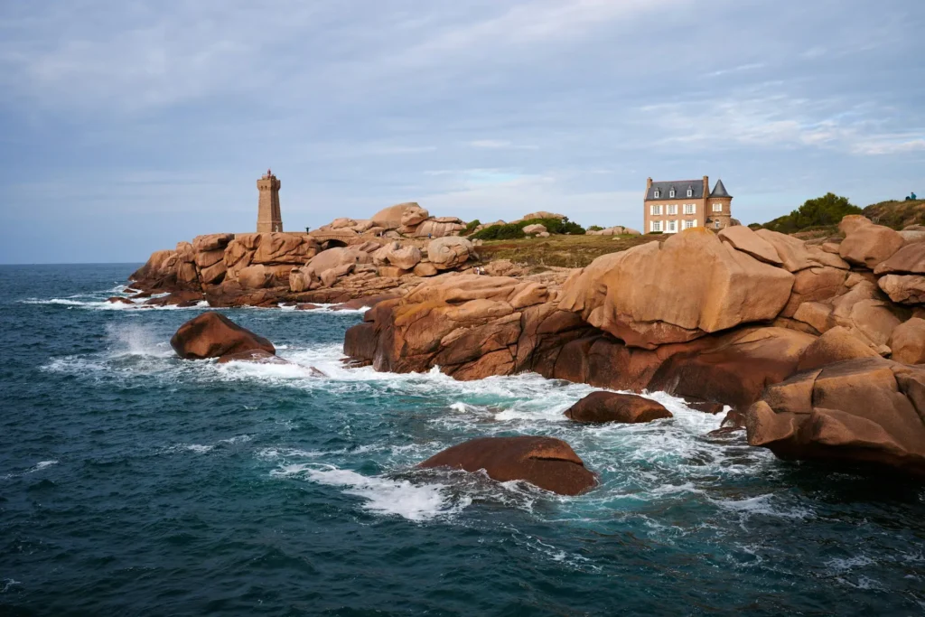 Gros plan sur les rochers roses et arrondis de Ploumanac’h en Bretagne, bordant l’eau turquoise